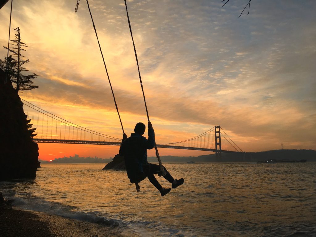 Kirby Cove swing at sunset on the beach with the Golden Gate Bridge near San Francisco 